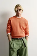 Jersey relaxed fit de punto tejido en hilatura de algodón con cuello redondo, manga larga y efecto lavado. Presenta un pequeño bordado en el delantero y acabados en rib. Colección especial Fruit of the Loom x Zara.