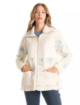 Chaqueta de corte relajado confeccionada en tejido tipo corderito color crema, combinada con paneles de matelassé en el frente y bolsillos. Presenta un delicado bordado floral en tonos azules sobre el corderito, cierre frontal metálico dorado y bolsillos de parche delanteros.