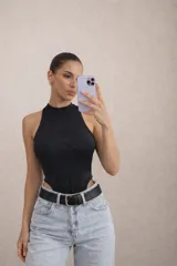 Body negro sin mangas con cuello alto y diseño tipo corset con costuras estructuradas en el frente.