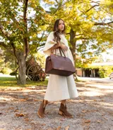 Botín de cuero vacuno color marrón oscuro, con taco de madera foliado en cuero de 5cm de altura, cierre lateral interno y horma de punta fina.