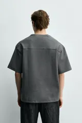 Sudadera de corte relajado confeccionada en tejido técnico interlock con mezcla de algodón, cuello redondo y manga corta.