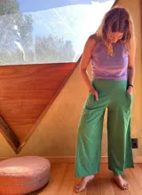 Pantalón tipo palazzo de tiro alto, confeccionado en jersey de algodón color verde. Presenta un diseño amplio con bolsillos laterales y una faja ancha en la cintura que proporciona soporte y ajuste.