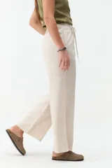 Pantalón de corte ancho y tiro medio, color verde militar, con cintura elástica ajustable mediante cordón y bolsillos laterales.