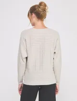 Buzo de punto calado en hilado fino, marca Allie Rose, de color gris. Presenta una silueta relajada con escote a la base, mangas largas de corte caído con puños ajustados y ruedo recto con pretina acanalada.