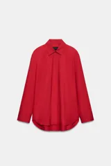 Camisa oversize verde de popelina de algodón, con cuello solapa, manga larga y cierre frontal con botones ocultos bajo solapa.