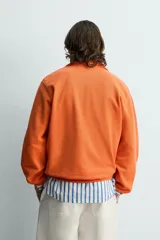Sudadera regular fit azul marino confeccionada en tejido de algodón con estructura piqué. Cuenta con cuello subido, cierre frontal de cremallera corta y mangas largas con acabados en rib.