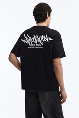 Remera de algodón negra con cuello redondo y diseño de estampado tipográfico en el pecho, corte holgado.