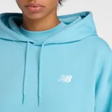 Canguro New Balance de dama, color celeste, con capucha ajustable con cordones, bolsillo frontal tipo canguro y logo de la marca bordado en el pecho.