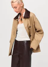 Pantalón de efecto piel con diseño recto y largo, tiro medio, cierre frontal con cremallera y botón, trabillas para cinturón y cinco bolsillos.