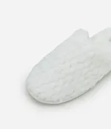 Pantufla cerrada de mujer con textura de peluche suave en color negro, diseñada para brindar comodidad en el hogar.