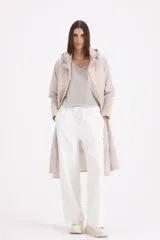 Pilotín largo con capucha, diseño combinado con secciones en matelassé en el pecho, mangas y ruedo. Cuenta con cierre frontal, bolsillos laterales y cordones ajustables en la capucha.