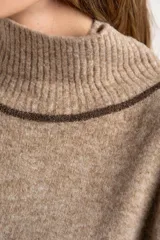 Polera oversize color beige melange, de punto con mangas largas y detalles de franjas marrones en las mangas y cuello.