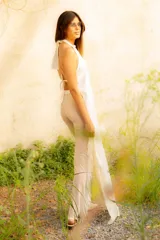 Top halter de satén color blanco, con escote en V y espalda descubierta con lazo para atar. Presenta una cola larga que cae por la espalda.