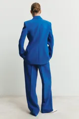 Pantalón de tiro alto con pernera recta, bolsillos laterales y cierre frontal con cremallera, botón y gancho.