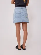 Falda de jean de corte recto y tiro medio, con diseño clásico de cinco bolsillos, cierre frontal con botón y costuras en contraste.