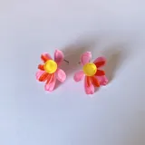 Aros tipo botón con forma de flor de pétalos turquesa y centro rosa y naranja.