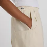 Pantalón de sarga color beige, con cintura elástica ajustable con cordón, bolsillos laterales de doble entrada, dobladillo con botón a presión y costuras inspiradas en la ropa utilitaria.