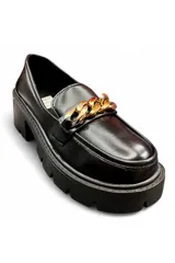 Mocasín de mujer color negro con acabado de charol, suela track robusta de plataforma y tacón cuadrado, con detalle de cadena dorada en el empeine.