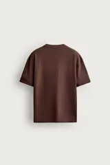 Camiseta relaxed fit confeccionada en tejido de algodón con textura irregular. Cuenta con cuello redondo y manga corta.