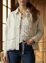 Sobrecamisa de algodón color crudo, con corte oversize, cierre frontal de botones y detalle de bordado broderie en el ruedo.