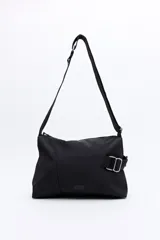 Cartera tipo bandolera de nylon color negro, con correa ajustable y detalle de hebilla metálica lateral. Presenta un diseño minimalista con cierre superior y logo sutil en la parte inferior.