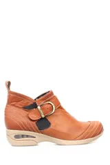 Botín de cuero color marrón con ajuste de hebilla y elástico lateral. Suela de goma con tecnología de burbuja de aire para mayor comodidad.