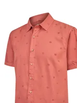 Camisa de manga corta color rojo con estampado sutil de motivos veraniegos, cuello camisero y cierre frontal con botones.