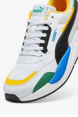 Championes deportivos Puma X-Ray en combinación de azul, gris y negro, con detalles en amarillo flúor y suela blanca y azul.
