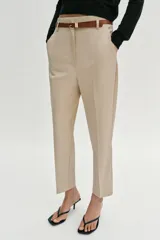 Pantalón tobillero de tiro medio, color azul marino, con bolsillos delanteros y cierre frontal con cremallera, botón y gancho. Incluye un cinturón fino de color marrón con hebilla metálica.