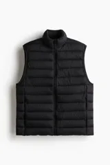 Chaleco acolchado de nylon rompevientos, color negro, con diseño guateado, cuello elevado y cierre frontal. Cuenta con bolsillos laterales con cierre y forro interior.