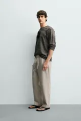 Pantalón de corte regular fit confeccionado en tejido mezcla de algodón, con cintura elástica ajustable mediante cordón, bolsillos laterales y bolsillos traseros de vivo.
