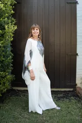 Pantalón tipo palazzo de gasa plisada en color blanco off-white. Presenta un diseño de pierna ancha, caída fluida y forro interno.