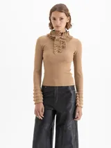 Sweater de tejido de punto fino color marrón, con ajuste al cuerpo, cuello alto con detalle de volados y moño, y mangas largas con puños acampanados con volados.