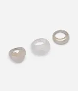 Kit de tres anillos con diseños variados, incluyendo un modelo con motivo de corazón, un aro voluminoso metálico y una pieza translúcida.