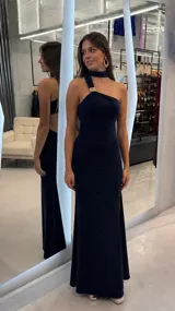 Vestido largo azul marino de corte sirena con acabado brillante, diseño de un solo hombro con detalle de hebilla metálica dorada y gargantilla incorporada.