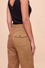Pantalón de tiro alto y calce barrel, con piernas amplias que se afinan hacia los tobillos. Diseño con bolsillos delanteros y traseros, presillas y cierre frontal con botón y cremallera.