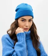 Gorro de punto tipo beanie color azul, con borde plegado y etiqueta pequeña aplicada en el lateral.