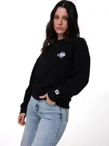 Buzo de cuello redondo color negro, con calce holgado y mangas largas. Presenta un gráfico estampado y bordado en el pecho izquierdo y una etiqueta con el logo de la marca en el puño de la manga izquierda. Posee puños, cuello y ruedo de punto acanalado.