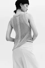 Pantalón sastrero de tiro alto en color beige, con perneras amplias y raya marcada en la parte delantera y trasera. Cuenta con cierre de cremallera, botón oculto y corchete, además de bolsillos decorativos insertados.