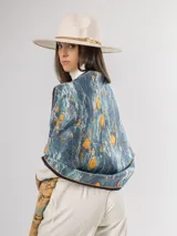 Pashmina de diseño artístico con estampado abstracto en tonos azules, celestes y amarillos. Presenta bordes con ribete oscuro y terminaciones con flecos cortos.