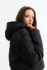 Campera puffer corta de color negro, con capucha, cierre frontal con cremallera y solapa con botones a presión.