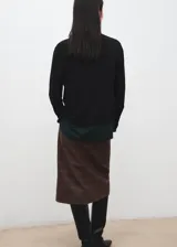 Cardigan de punto fino color negro, con cuello en V, manga larga y cierre frontal de botones.