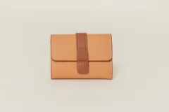 Billetera color tostado de símil cuero con cierre de solapa con broche marrón.