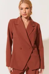 Blazer marrón de corte entallado, doble botonadura y solapas clásicas.