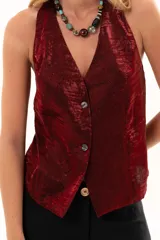 Chaleco de corte sastrero en color bordó, con acabado satinado y textura arrugada. Presenta escote en V profundo, cierre frontal con botones y diseño sin mangas.