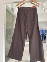 Pantalón de jean color marrón tabaco, de corte recto y pierna ancha, con tajo lateral en el ruedo.