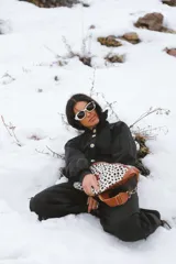 Riñonera de gran tamaño con diseño de estampado animal print de dálmata en la parte frontal y detalles en cuero color camel. Cuenta con correa ajustable y cierre metálico.