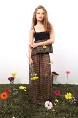 Falda larga de corte recto con caída fluida, confeccionada en tejido de telar con diseño a cuadros. Presenta una pretina tejida en punto elástico y un tajo lateral que aporta movimiento.