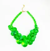 Collar de cuentas esféricas de resina translúcida color verde, con cierre de mosquetón y cadena dorada para regular el largo.