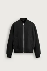 Cazadora bomber negra regular fit confeccionada en tejido con interior efecto pelo, cuello, puños y bajo en rib elástico, bolsillos frontales de vivo y cierre con cremallera metálica.